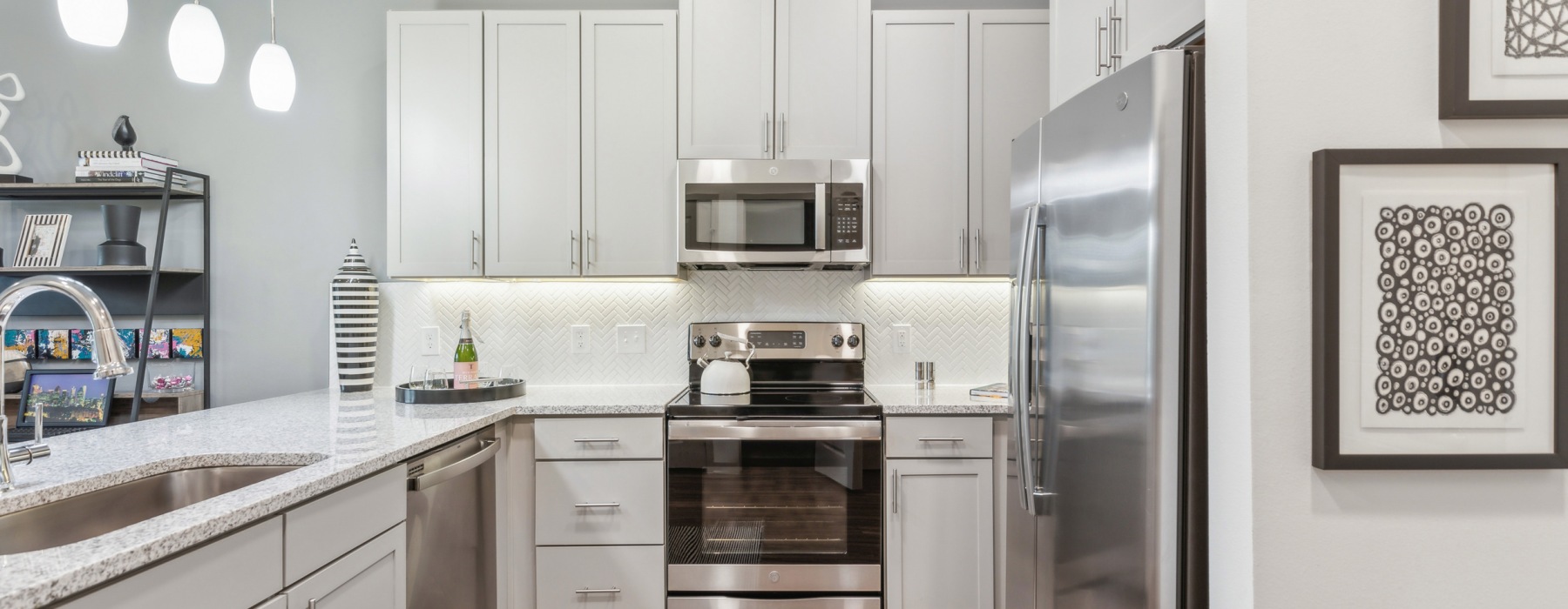 A modern open-concept living space with kitchen island at McKinney Terrace 1- to 3-bedroom apartments in McKinney, TX.