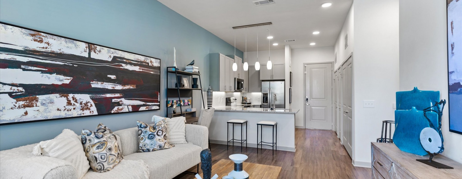 A modern open-concept living space with kitchen island at McKinney Terrace 1- to 3-bedroom apartments in McKinney, TX.
